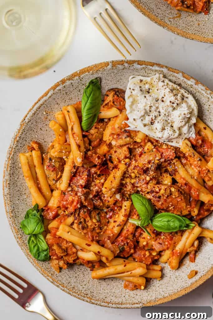 casarecce pasta in a bowl with fresh herbs and a fork