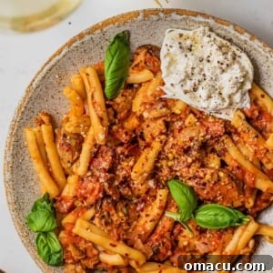 casarecce pasta in a bowl with fresh herbs and a fork