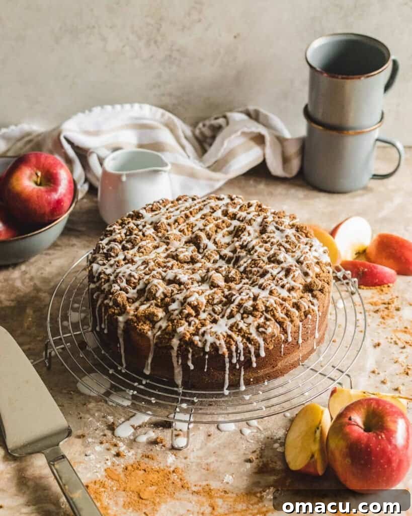 A delicious brown butter coffee cake with a cinnamon swirl, cooling on a rack next to fresh apples, showcasing the versatility of brown butter.
