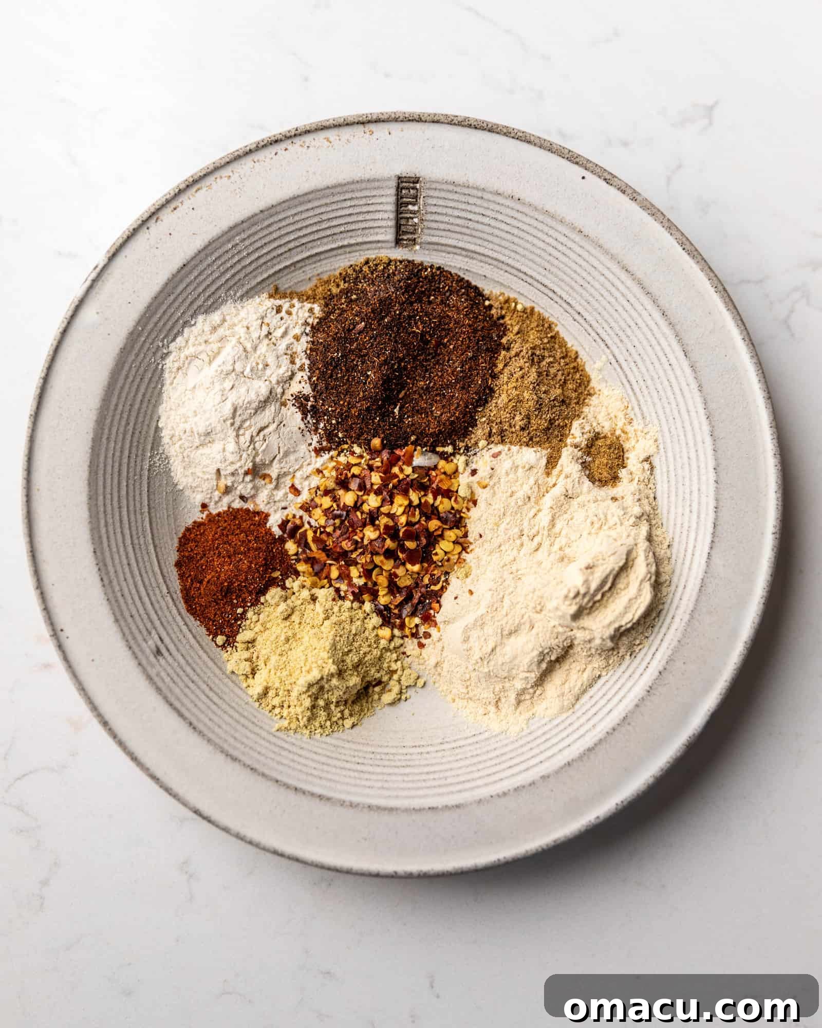 A vibrant array of dry rub seasonings expertly arranged on a plate, ready to flavor the pork.