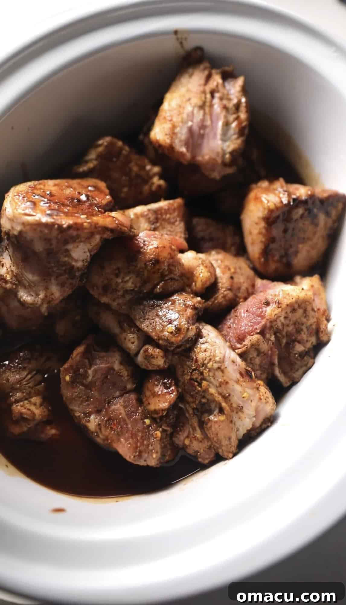Perfectly seared pork chunks nestled within a slow cooker, ready for braising.