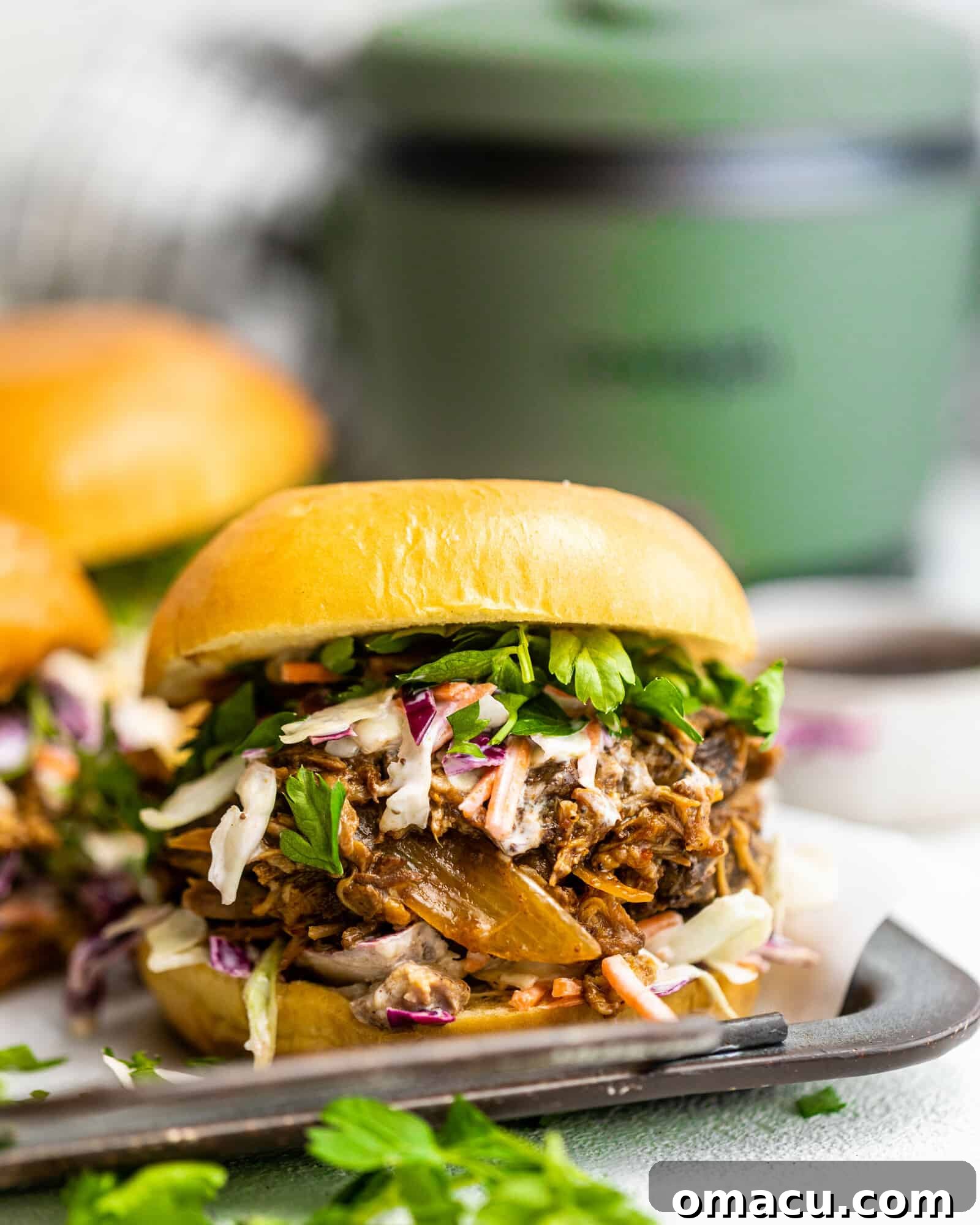 A delectable BBQ pulled pork sandwich presented on a clean white surface, highlighting its appetizing appeal.