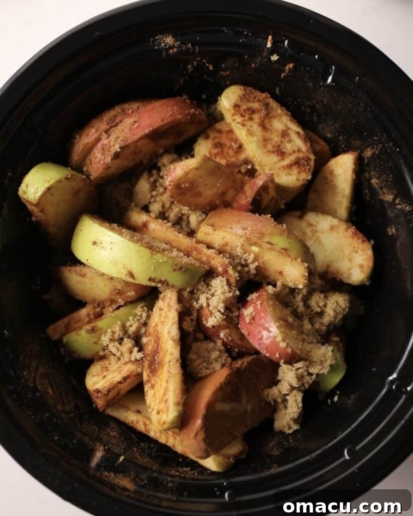 fruit in a slow cooker tossed in brown sugar and spices