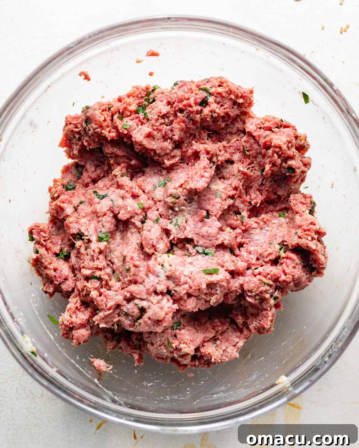 ground beef mixture mixed together in a bowl to make the meatballs.