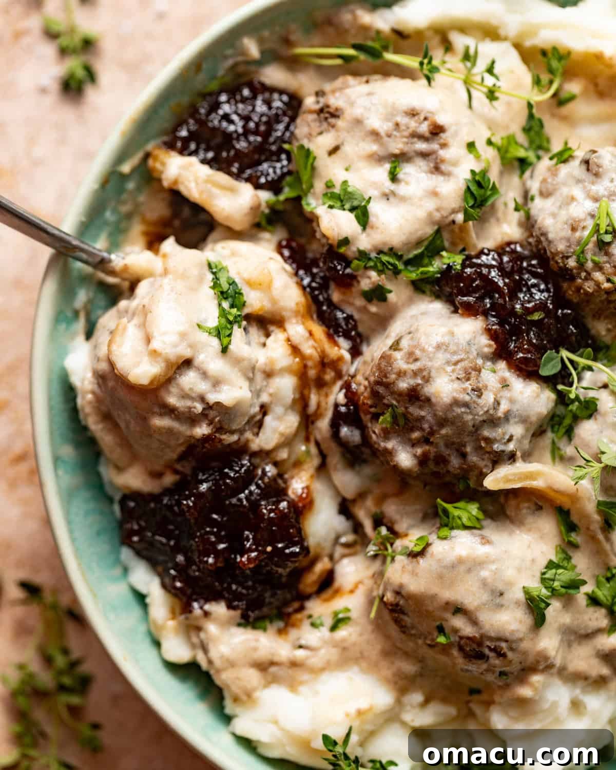 up close photo of crock pot swedish meatballs in a bowl with a spoon.