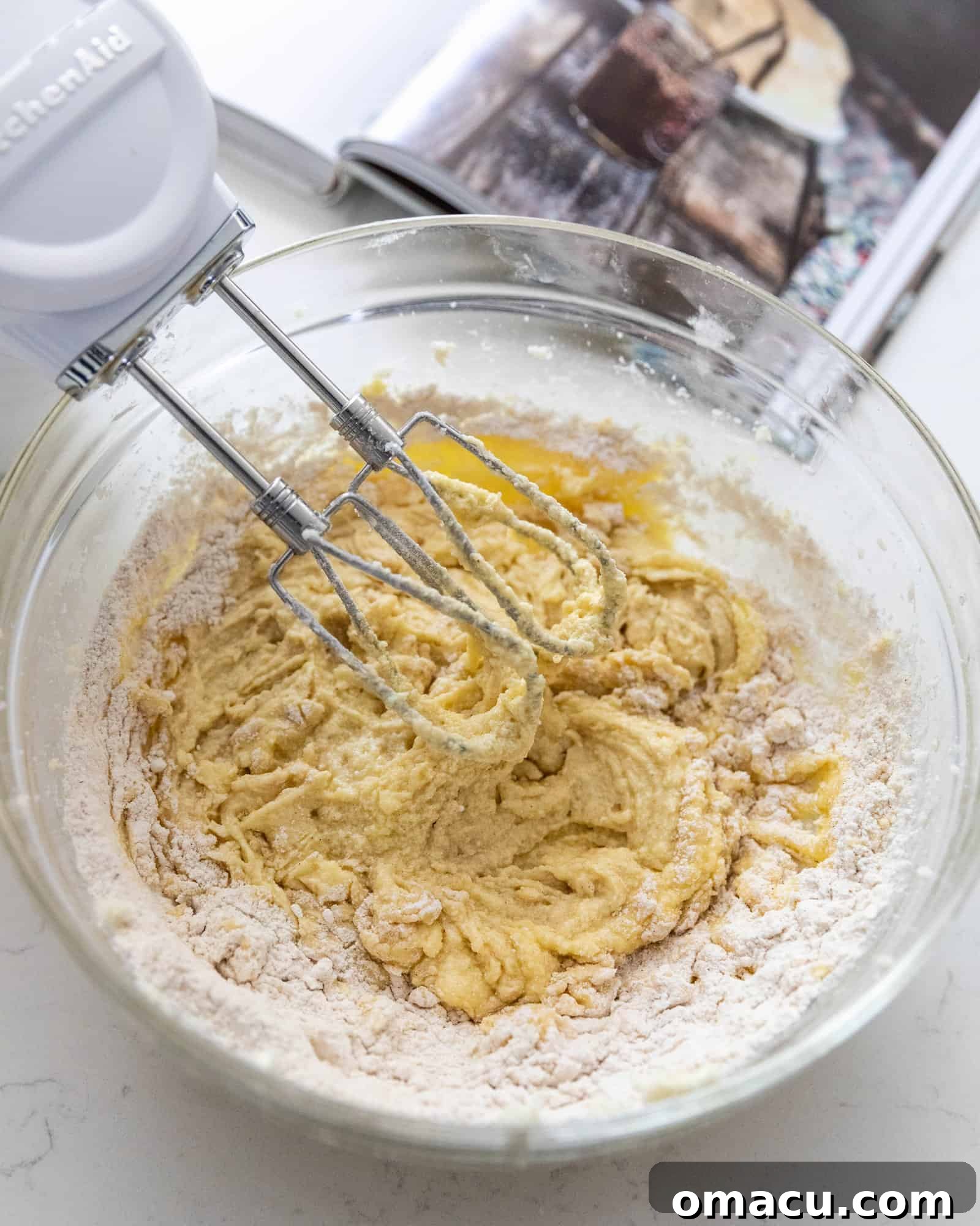 Butter and sugar thoroughly creamed together in a mixing bowl, illustrating a key step in cake preparation.