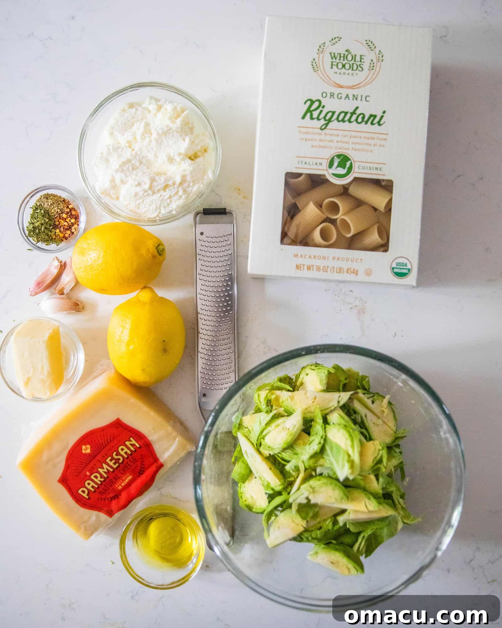 Fresh ingredients laid out on a white table, ready to be prepped for making lemon ricotta pasta.