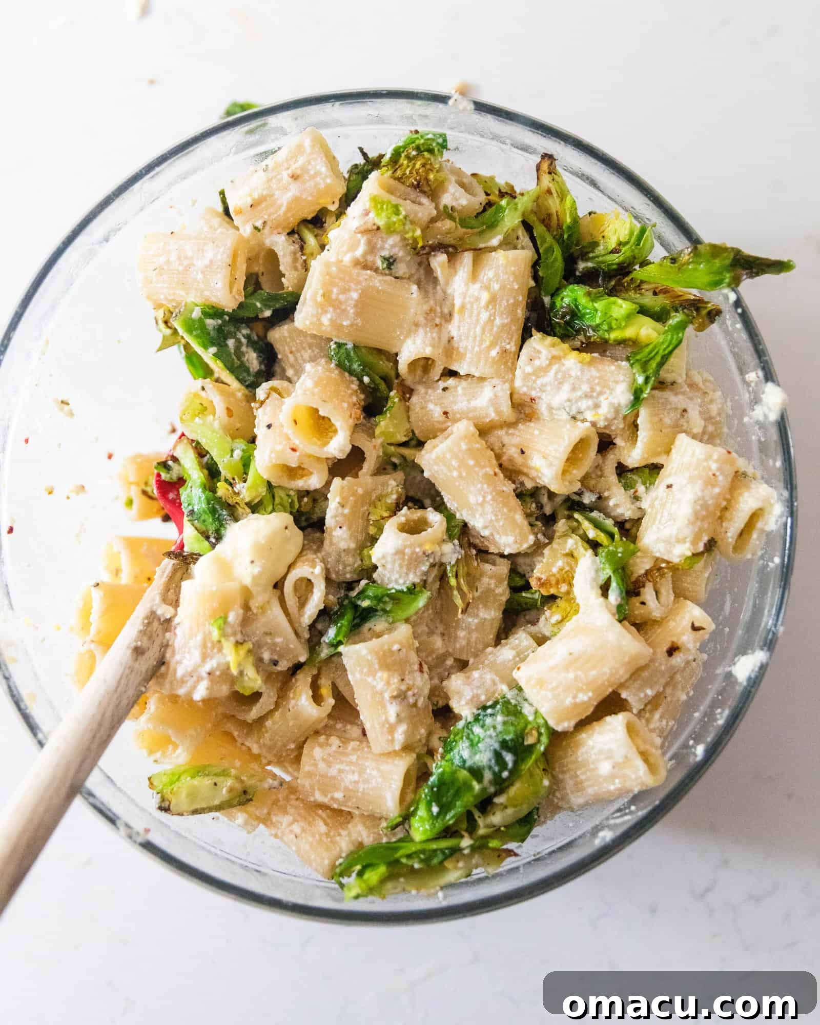 A large bowl filled with lemon ricotta pasta and roasted Brussels sprouts, ready to be served family-style.