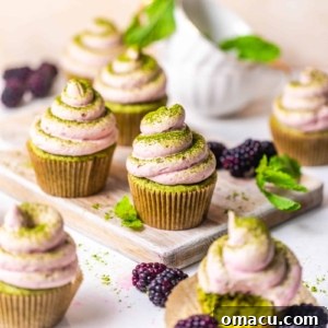 matcha cupcakes on a table with a tea cup and berries.