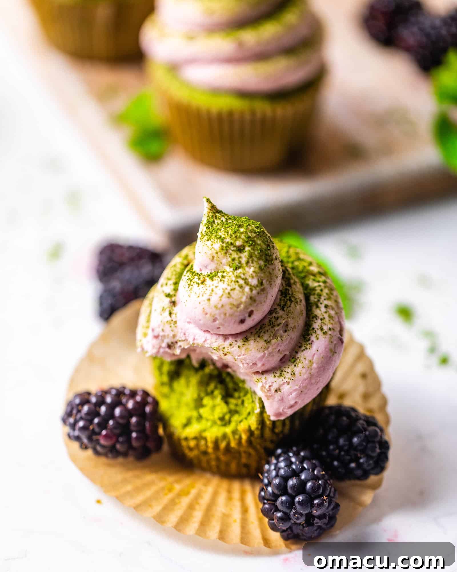 a matcha cupcake with a bite taken out of it.