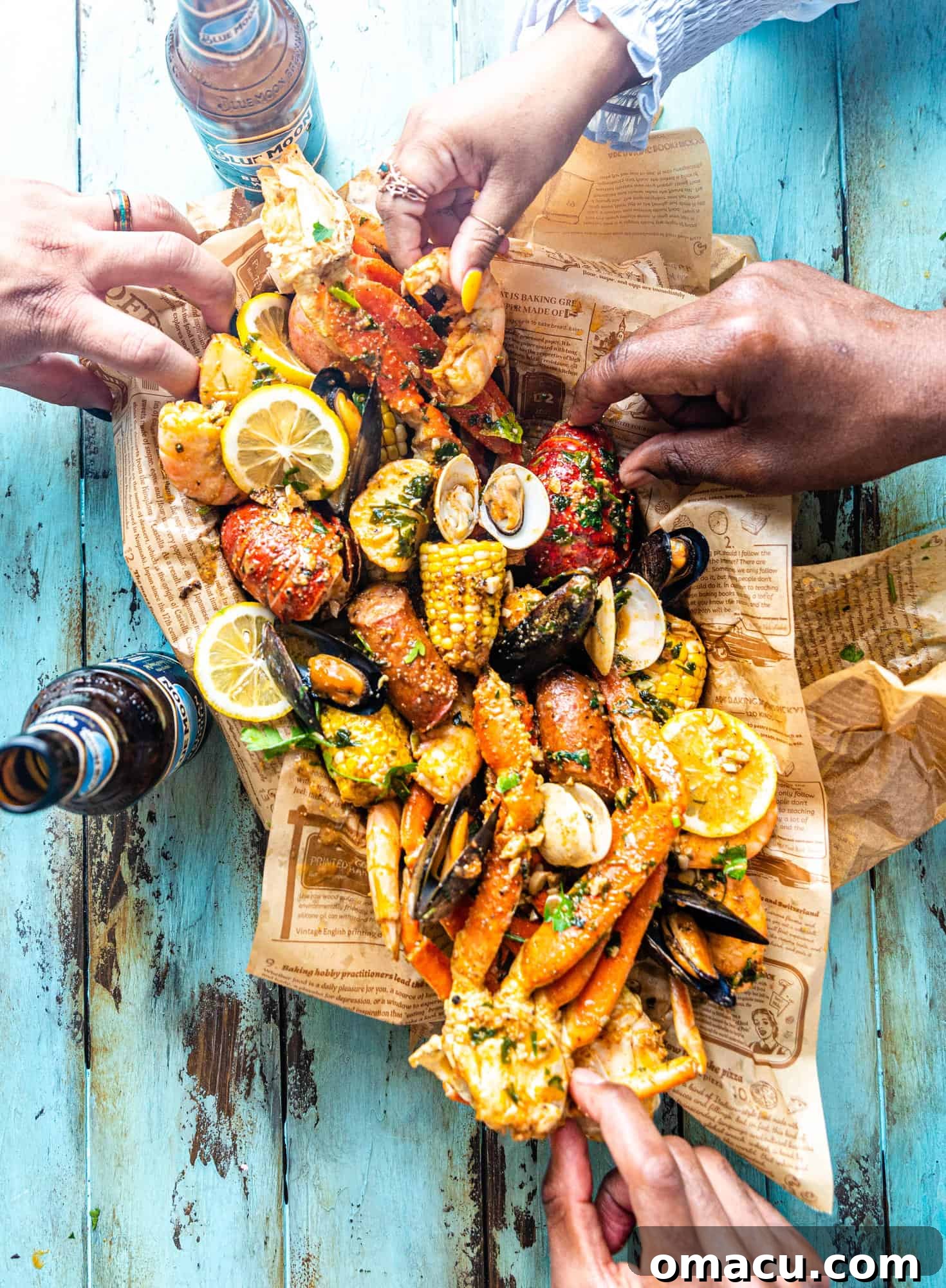 Hands reaching into a large bowl filled with a variety of delicious seafood from a recent boil, ready to be enjoyed.