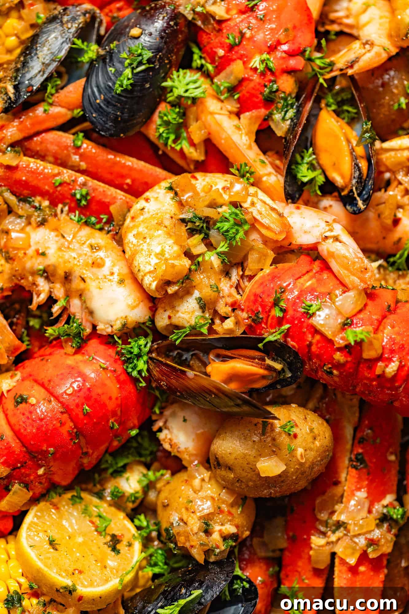 A close-up view of a vibrant Cajun seafood boil, featuring plump shrimp, luxurious lobster tails, tender mussels and clams, alongside bright lemon wedges, all garnished with fresh parsley and drizzled with a rich seafood boil sauce.