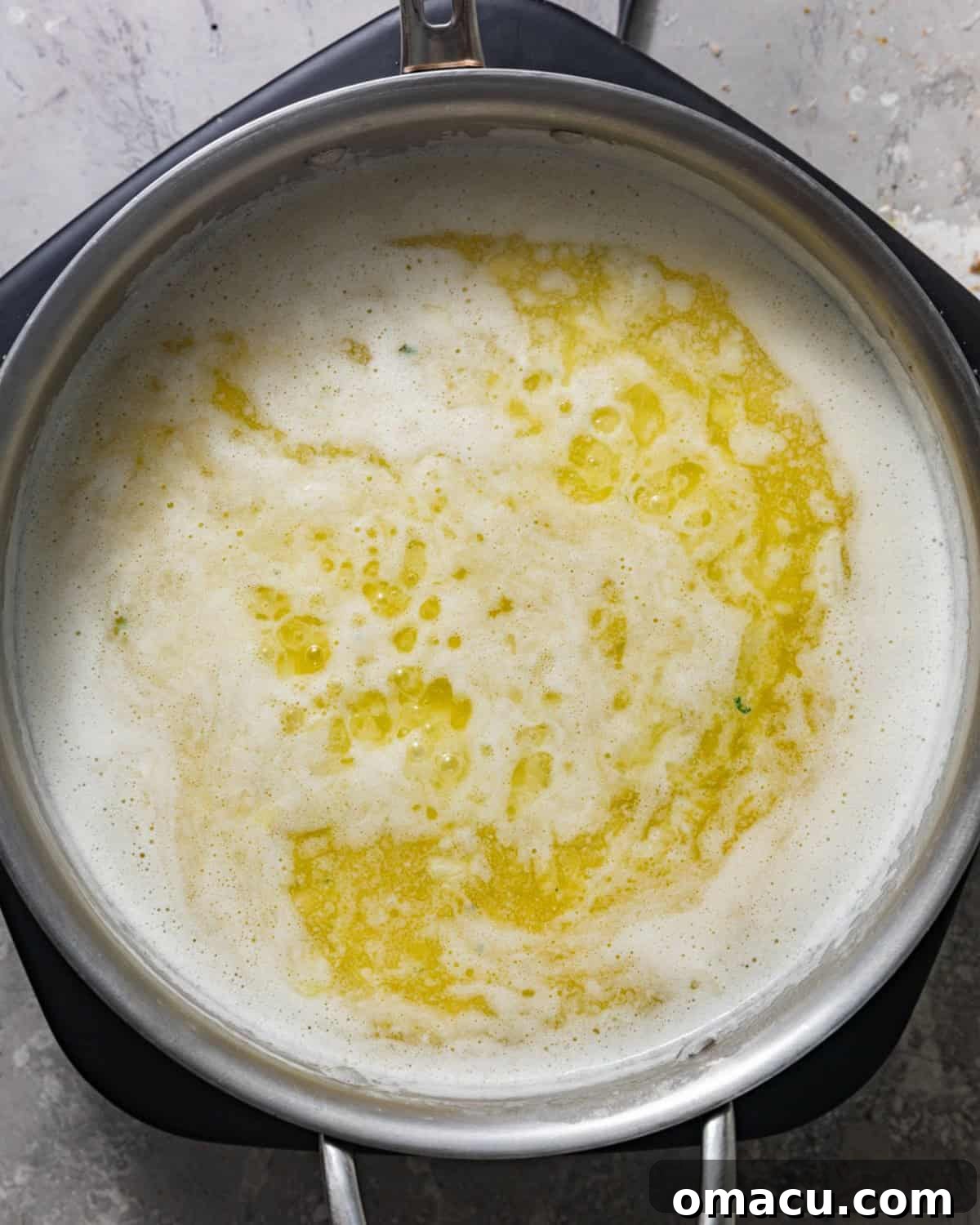 Rich butter melted in a skillet, gently sizzling over medium-low heat, forming the fragrant base for the homemade seafood boil sauce.