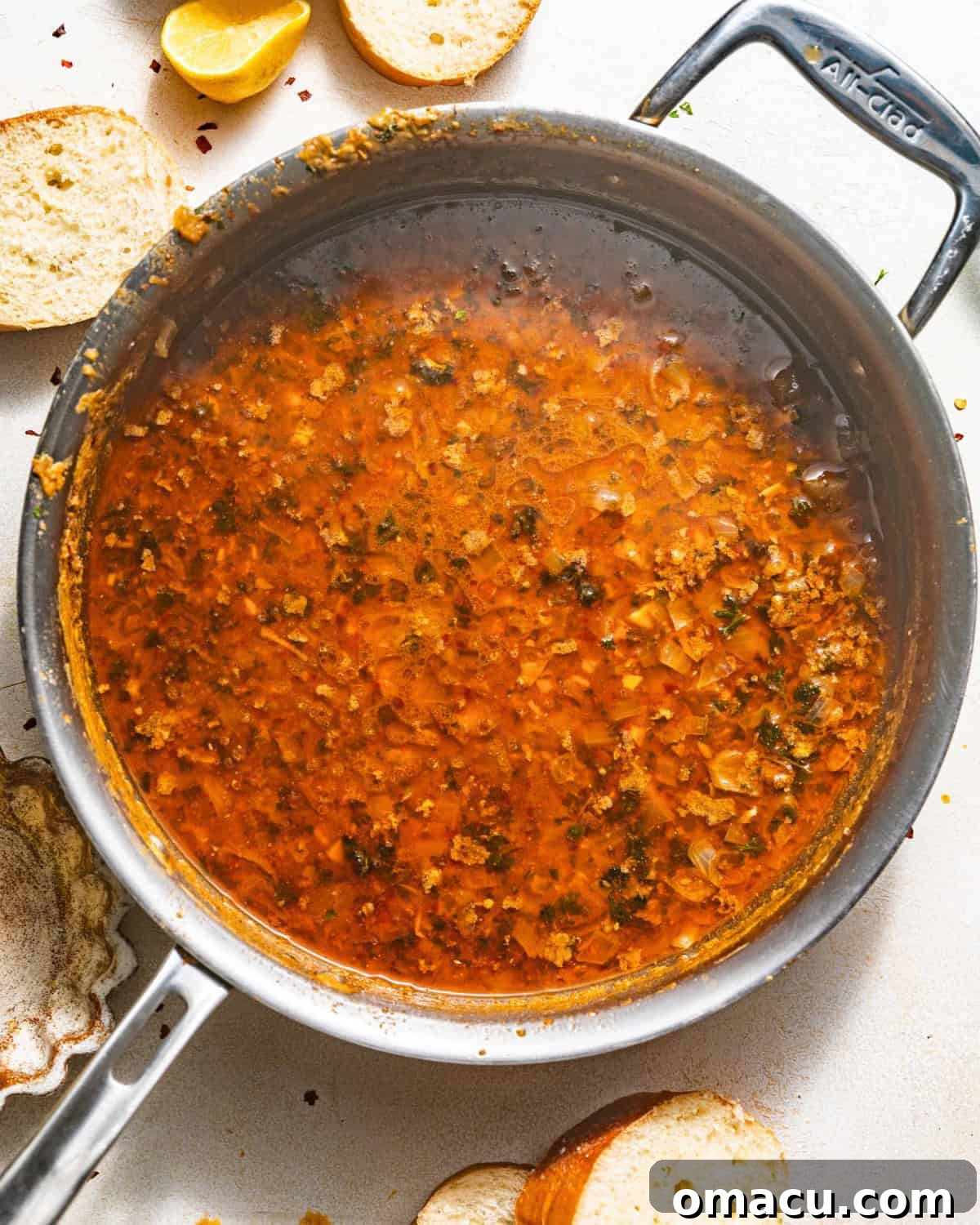 A vibrant, thick seafood boil sauce simmering gently in a skillet, rich with butter, garlic, and spices, ready to be poured over a delicious seafood feast.