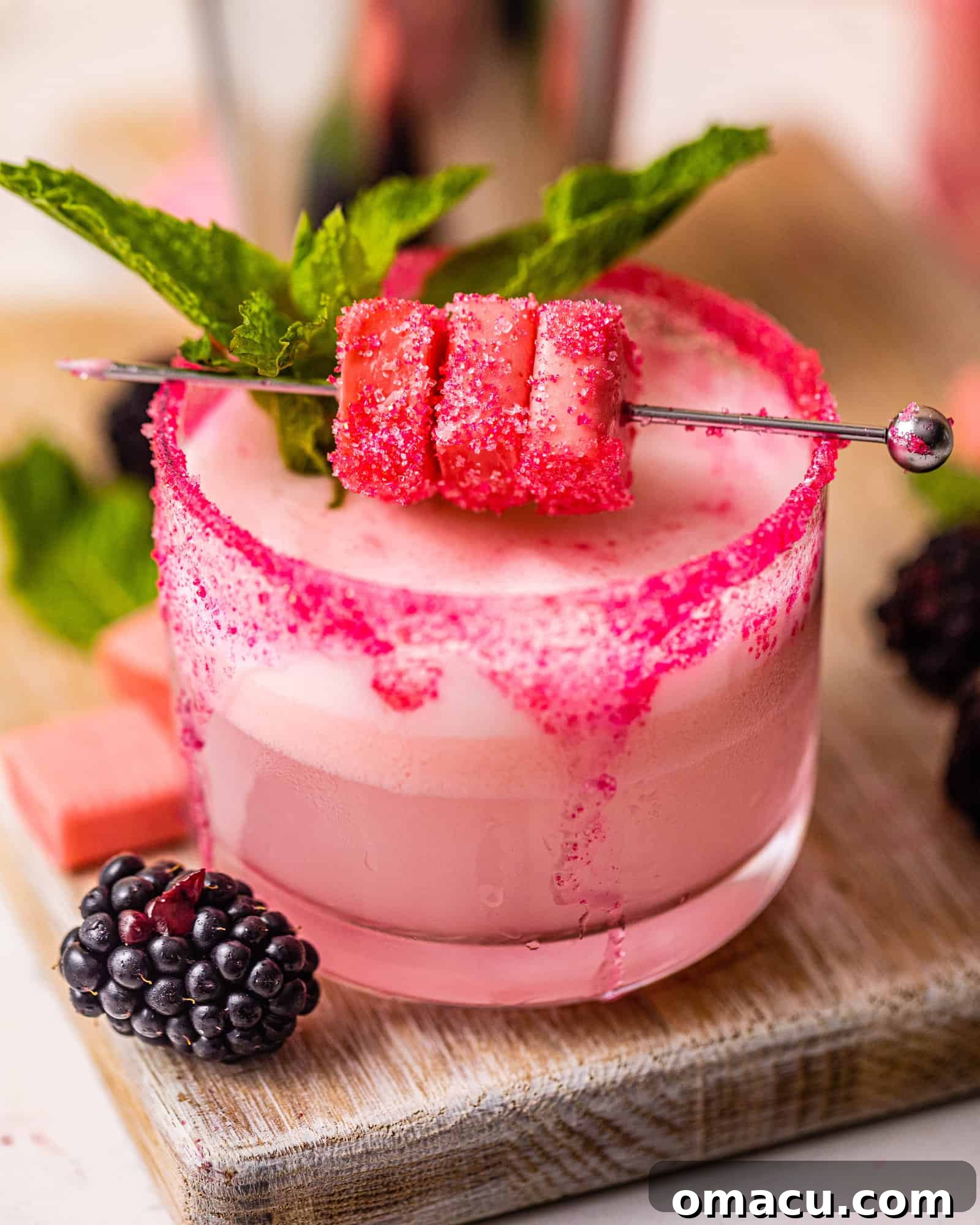 A beautifully presented pink Starburst shot in a glass on a serving board.