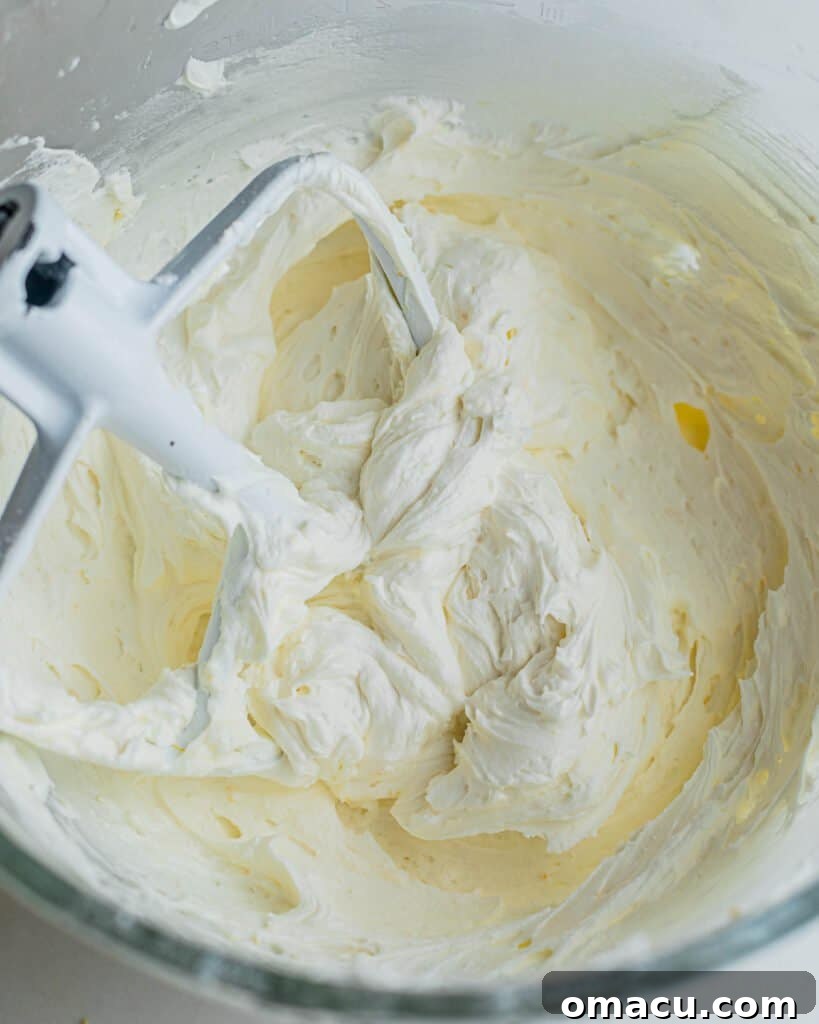 Smooth, creamy lemon buttercream frosting in a mixing bowl with a paddle attachment, perfectly prepared and ready for piping.