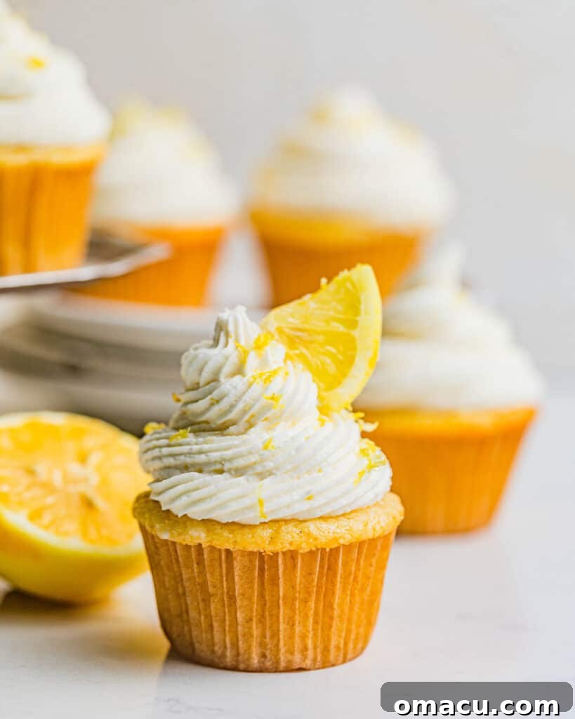 Lemon drizzle cupcakes beautifully arranged on a table, garnished with fresh lemon slices, highlighting their fresh and inviting presentation.