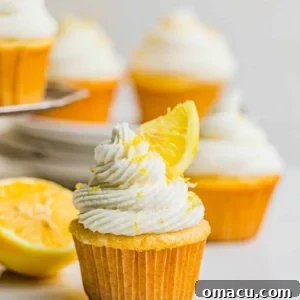 lemon drizzle cupcakes on a table with sliced lemons