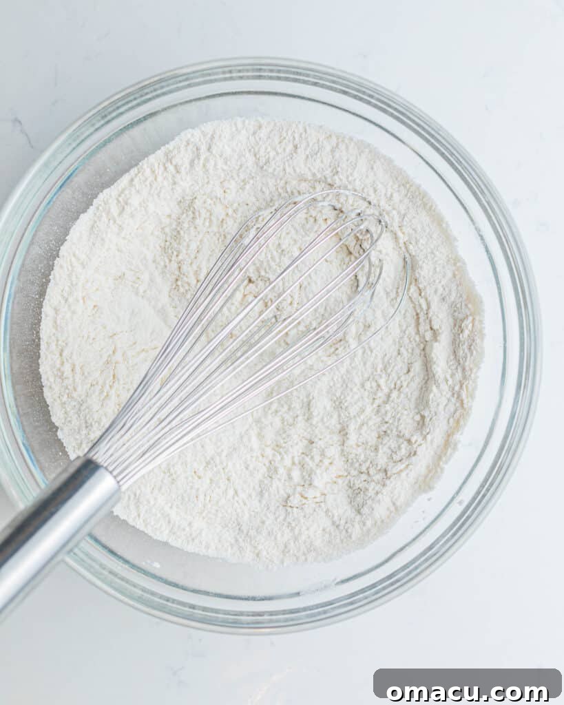 Step-by-step image: Flour, baking powder, baking soda, and salt mixed together in a bowl, showcasing the combined dry ingredients for the lemon cupcake recipe.