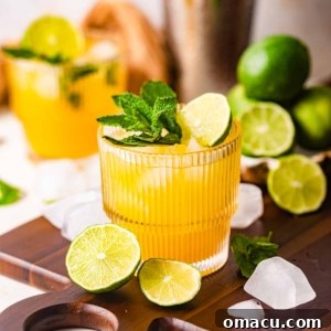 Mango Mojitos on a serving tray with limes and ice cubes