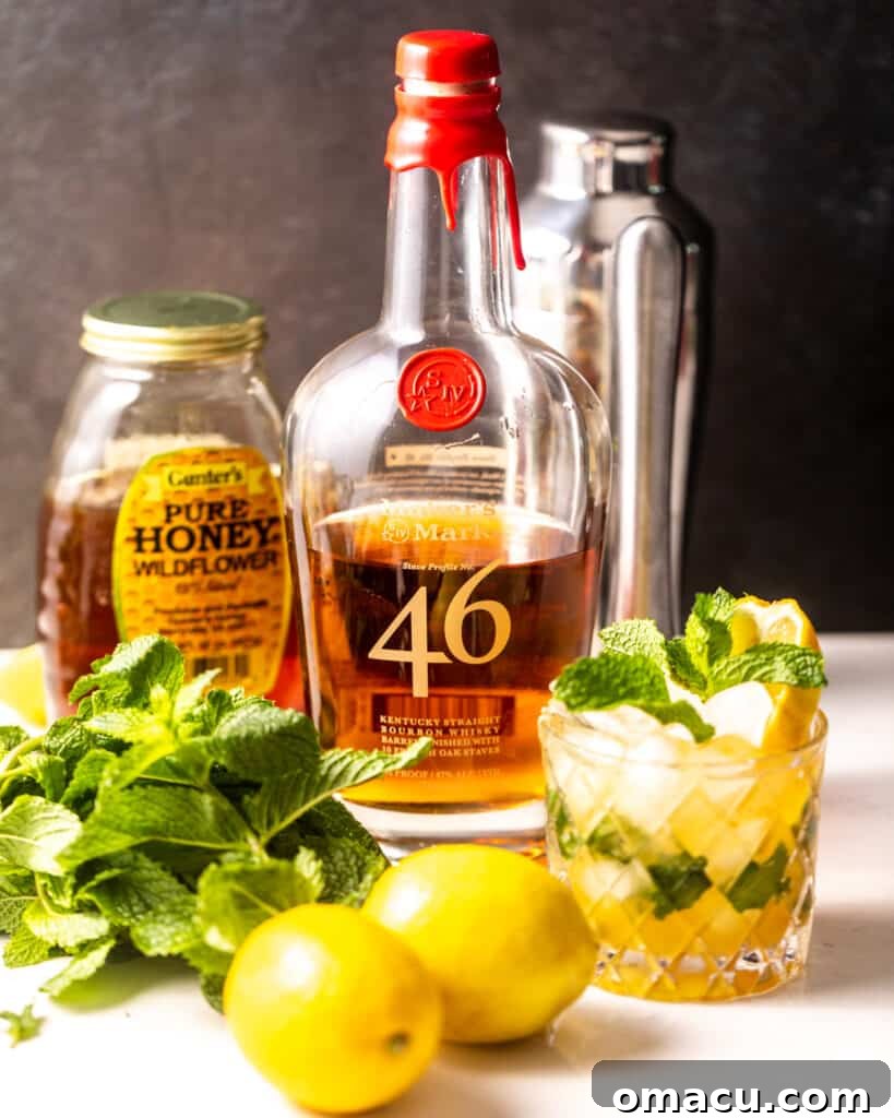 The essential ingredients for a Bourbon Smash neatly arranged: vibrant lemons, a bottle of premium whiskey bourbon, fresh green mint leaves, and a jar of golden honey.