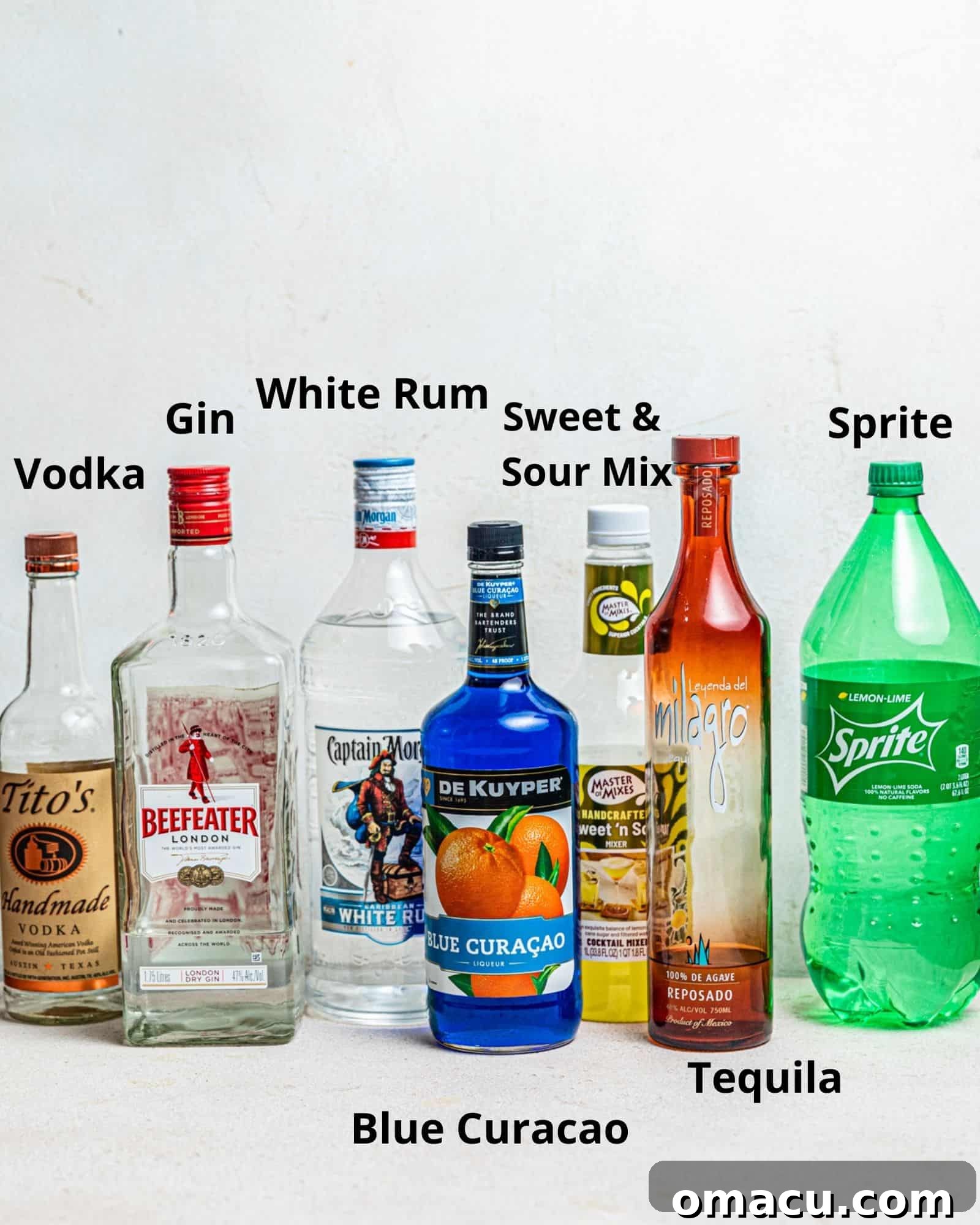 The ingredients needed to make an AMF drink - vodka, gin, white rum, blue curacao, tequila, sweet and sour mix, and lemon lime soda.