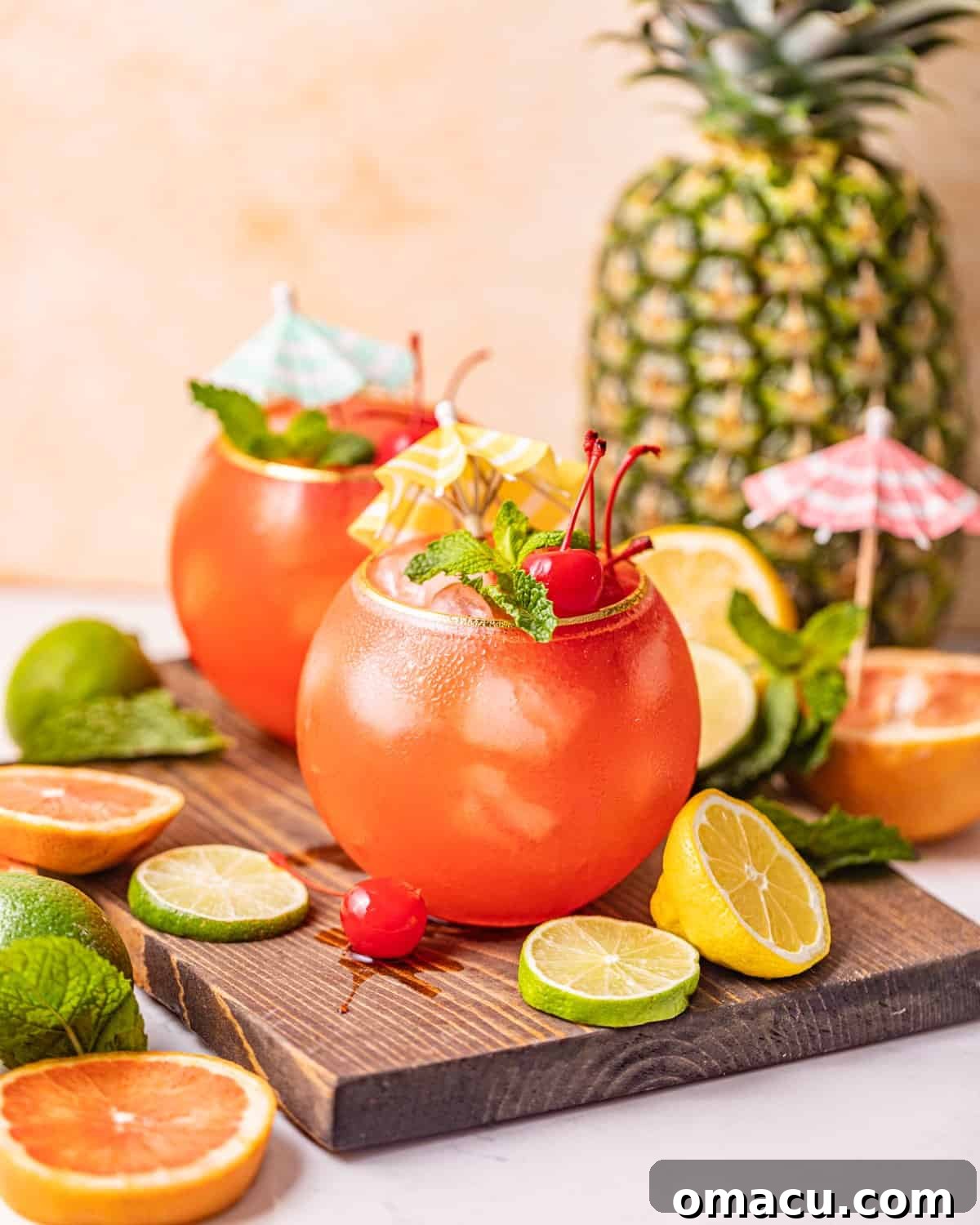 Two Bahama Mamas elegantly presented on a brown serving tray, accompanied by a fresh pineapple for garnish.