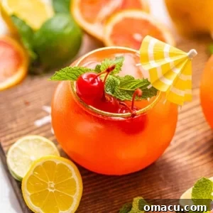 One Bahama Mama in a glass garnished with a tiny umbrella and maraschino cherries, showcasing its vibrant appeal.