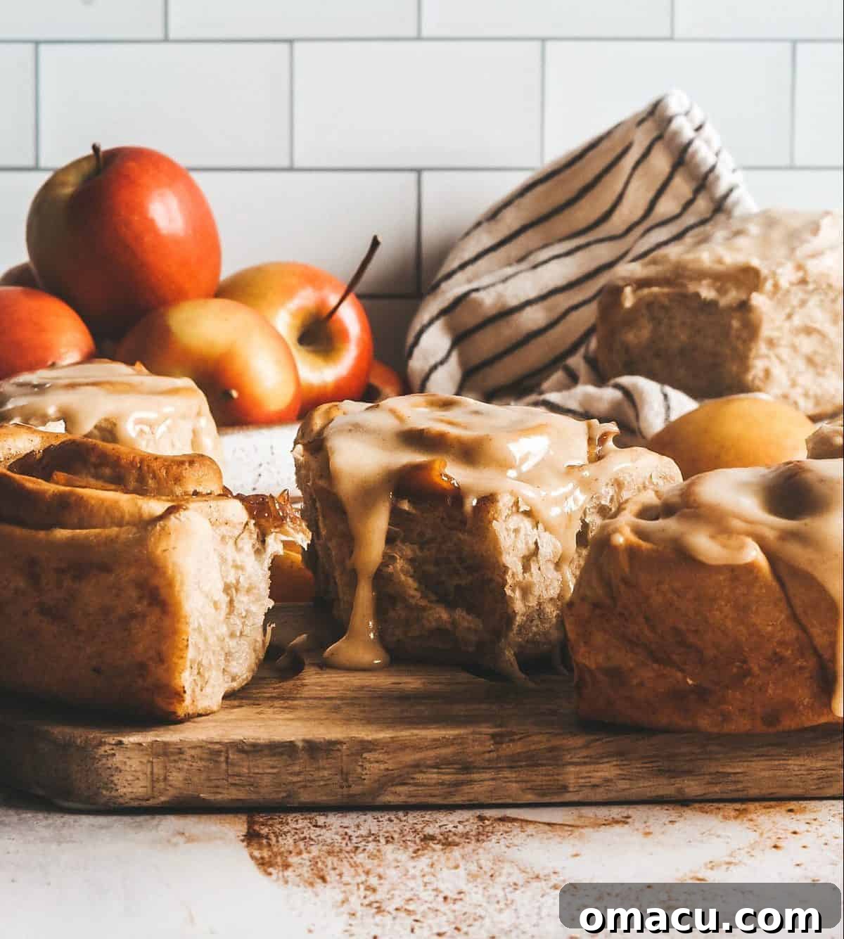Close-up of apple filling being spread onto rolled out cinnamon roll dough.