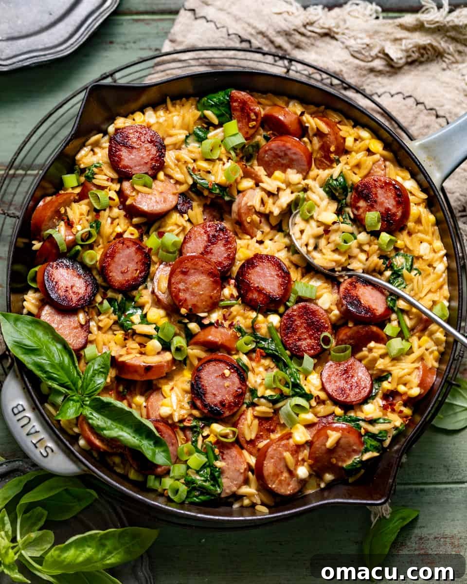 cajun orzo topped with sausage, fresh basil, and diced green onions in a skillet, showcasing the beauty of cast iron cooking.