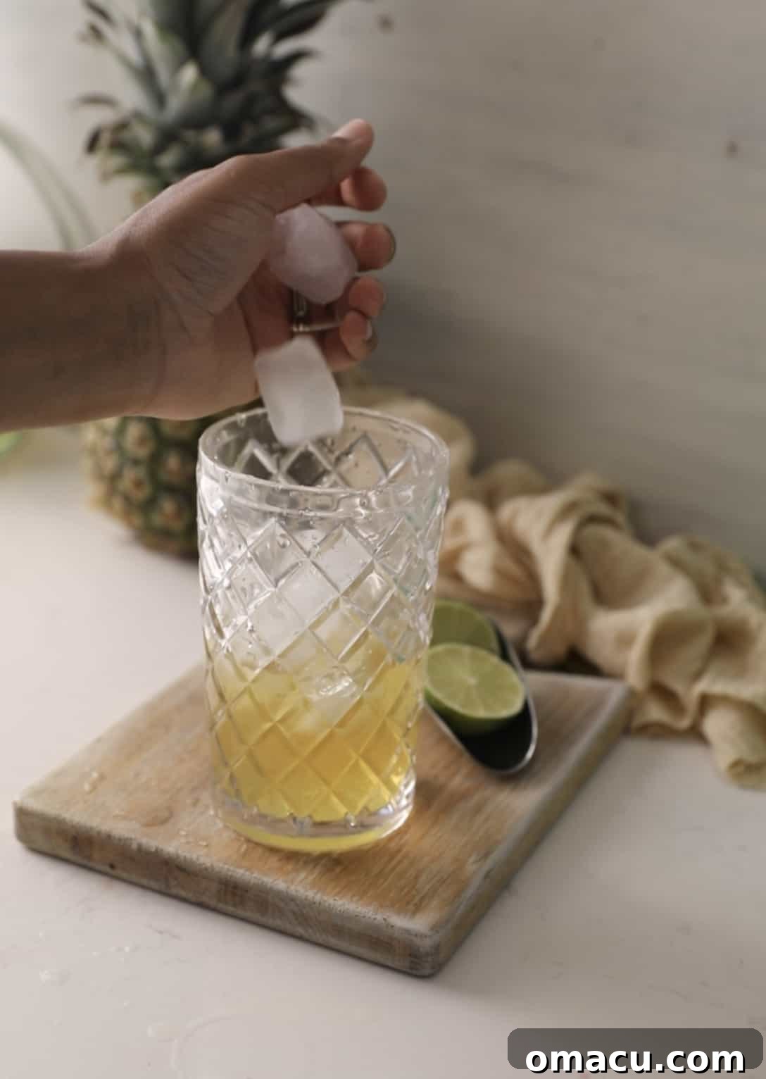 Adding ice cubes to a cocktail shaker, preparing to chill and mix the Water Moccasin shot ingredients.