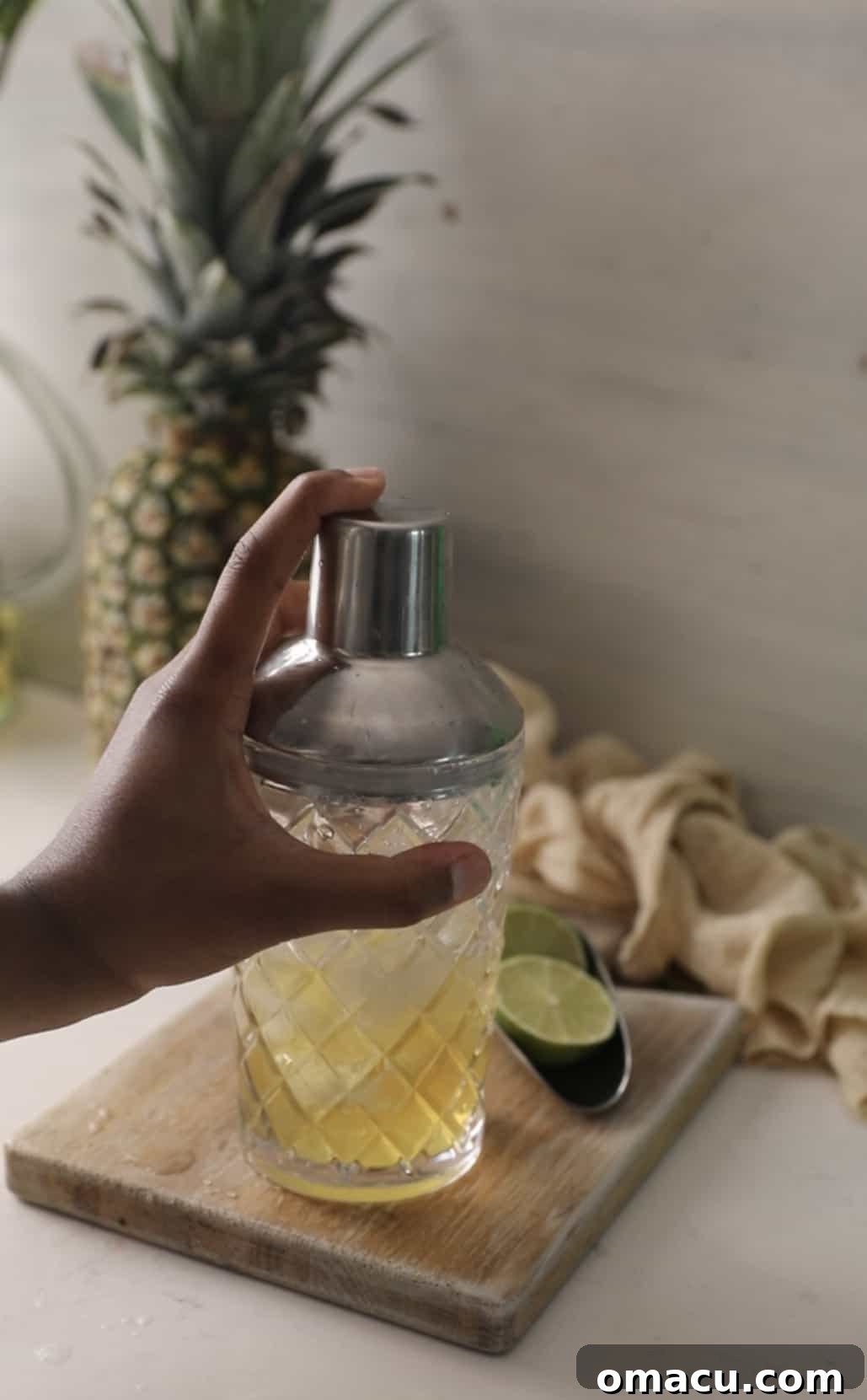 A cocktail shaker being vigorously shaken, expertly mixing the Water Moccasin shot ingredients with ice.