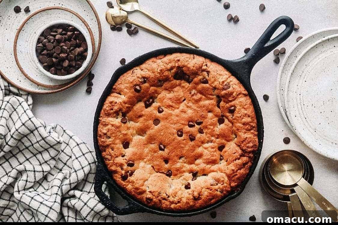 A raw Triple Chocolate Chip Skillet Cookie dough spread in a cast-iron pan, ready for baking.