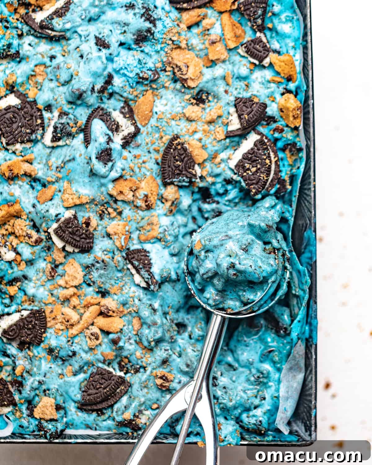 bright blue cookie monster ice cream in a pan with an ice cream scoop.
