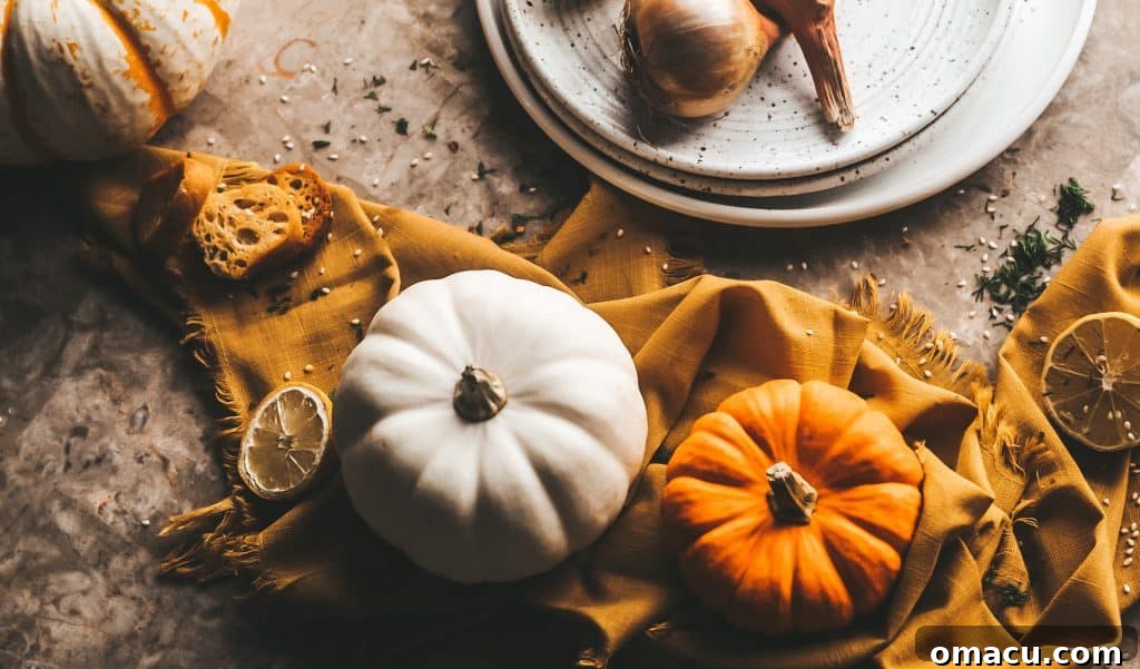 Close-up of the smooth, creamy texture of roasted red pepper and pumpkin soup, with garnishes of sage and red pepper flakes, highlighting its rich warmth.