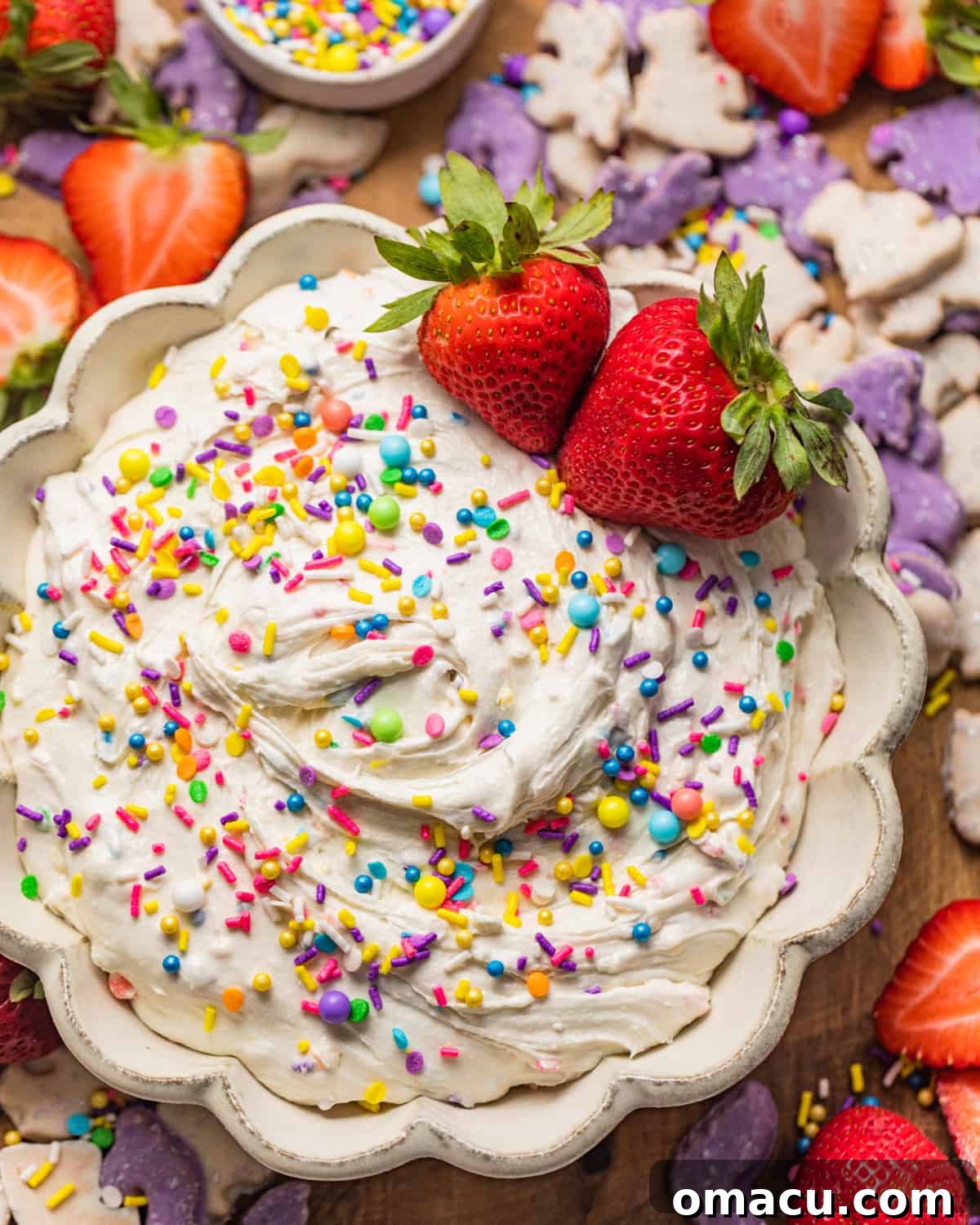 A vibrant bowl of homemade Dunkaroo Dip, generously garnished with colorful rainbow sprinkles and fresh strawberries, ready for dipping.