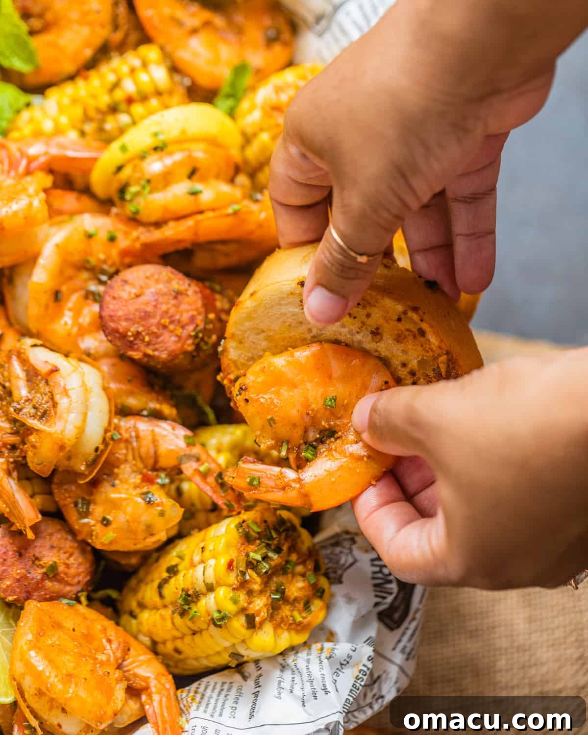 a hand grabbing shrimp and placing it onto a piece of sliced bread.