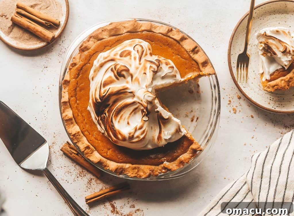 A perfectly baked sage browned butter pumpkin pie with a slice cut out, showcasing its creamy filling and golden crust.