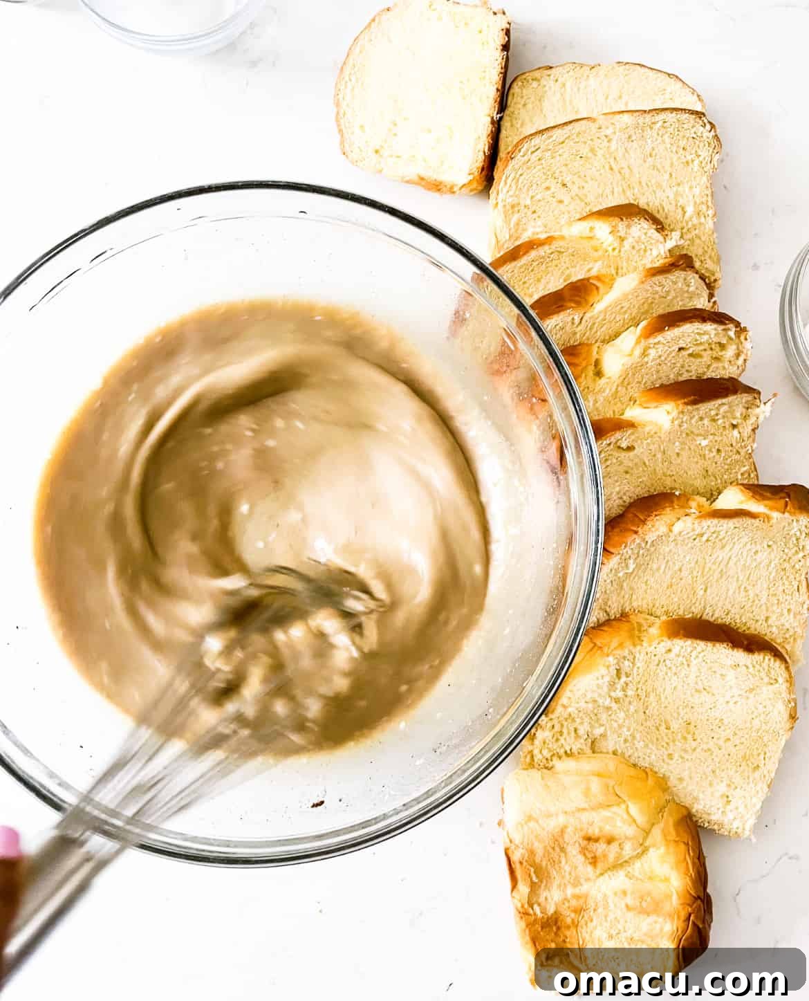 A bowl containing melted butter and brown sugar, being whisked together until smooth and combined.