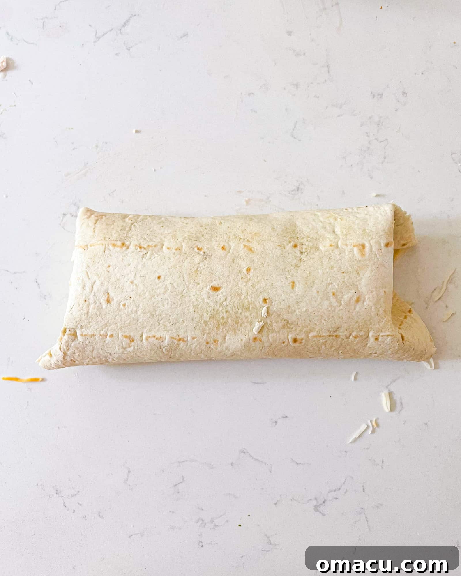 A freshly prepared and perfectly rolled chicken bacon ranch wrap.