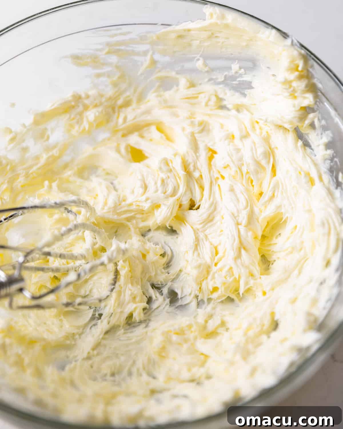 Whipped cold butter in a large mixing bowl, showing its creamy texture before adding sugar.