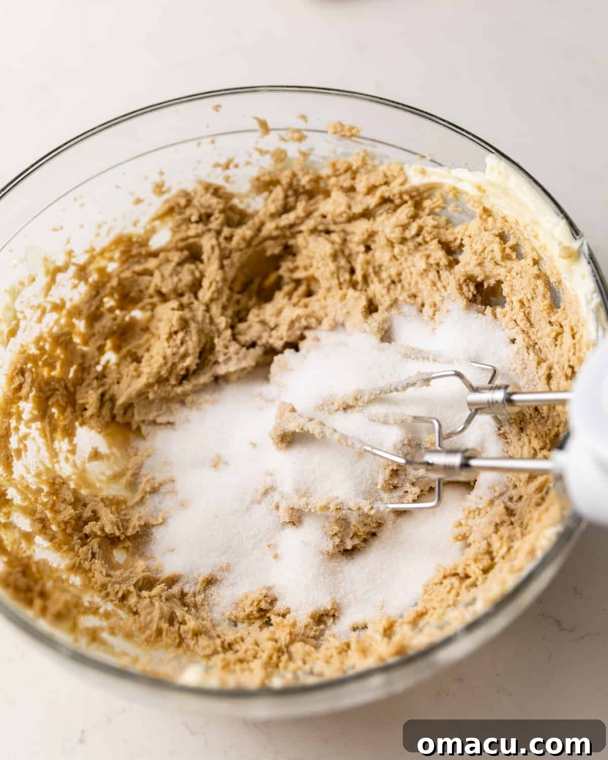 Butter, granulated sugar, and brown sugar combined in a large mixing bowl, ready to be creamed.
