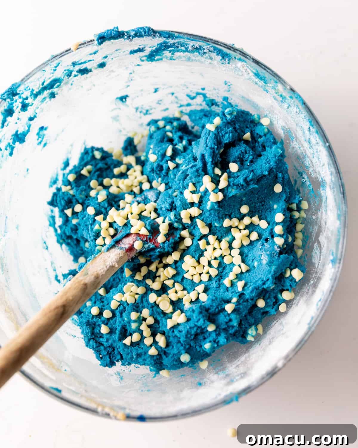 Blue cookie dough with white chocolate chips beautifully folded in, demonstrating the final dough consistency.