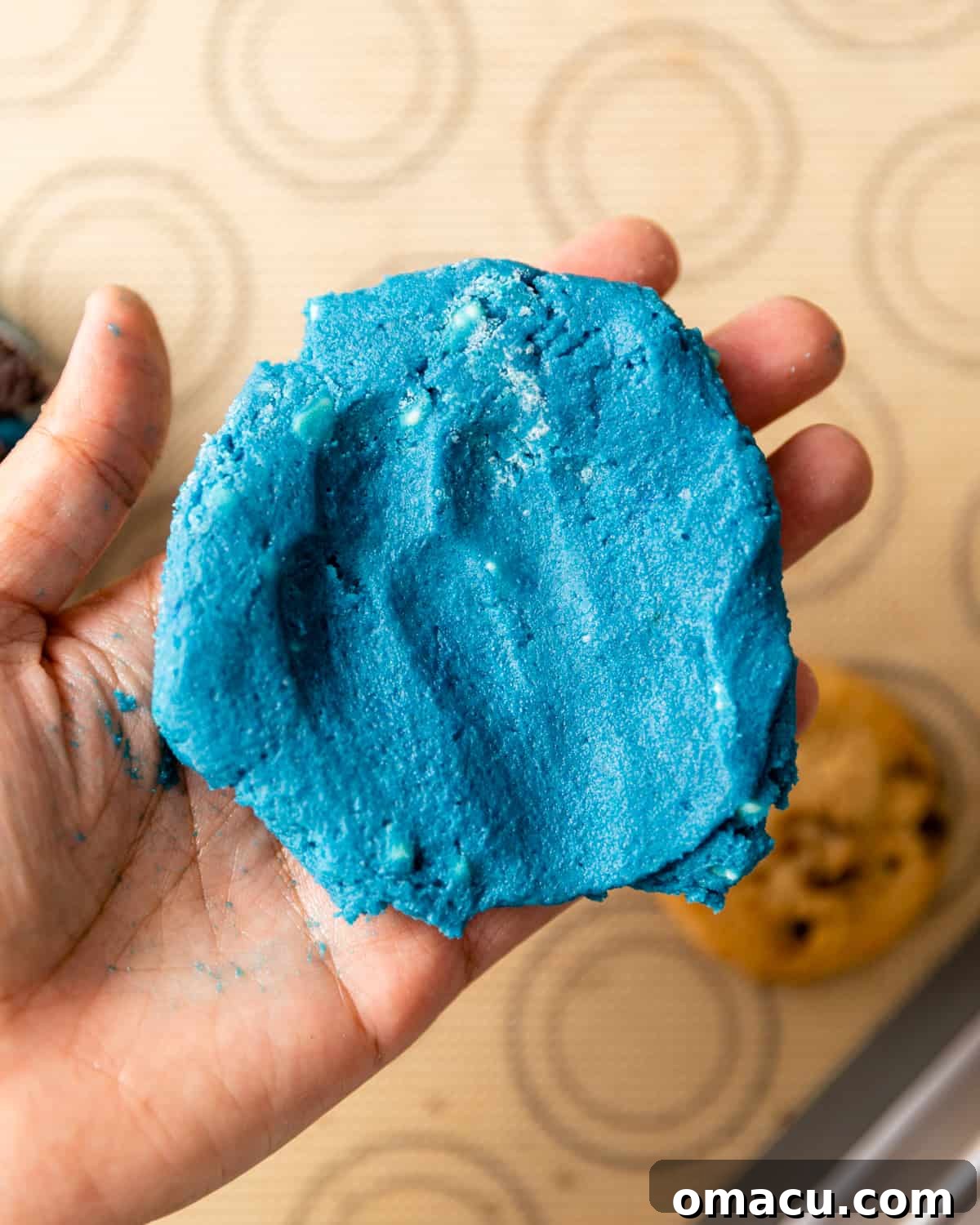 Cookie dough flattened into a disc, ready for stuffing with a cookie.