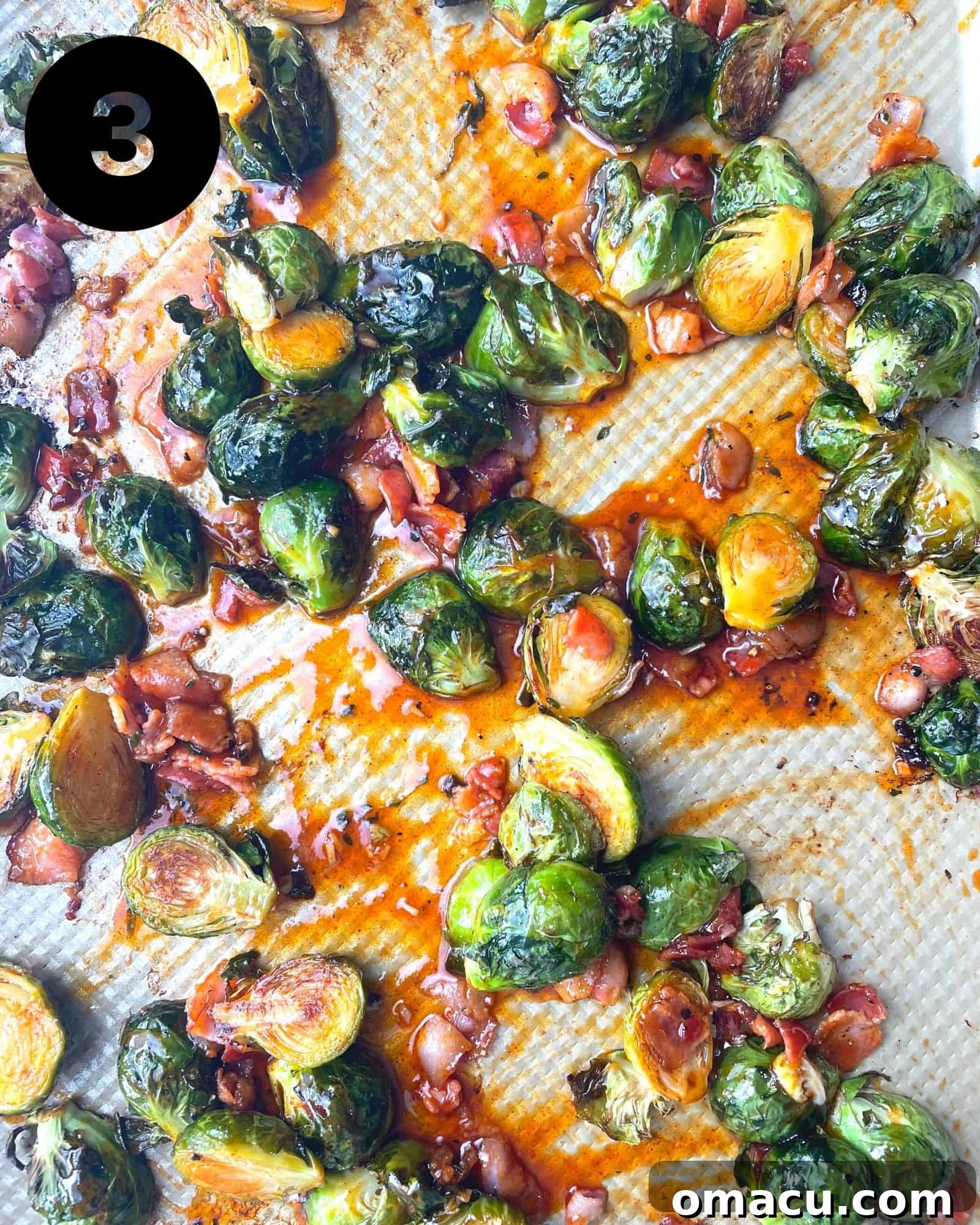 Roasted brussels sprouts and crispy bacon being tossed in a bowl with the honey sriracha sauce.