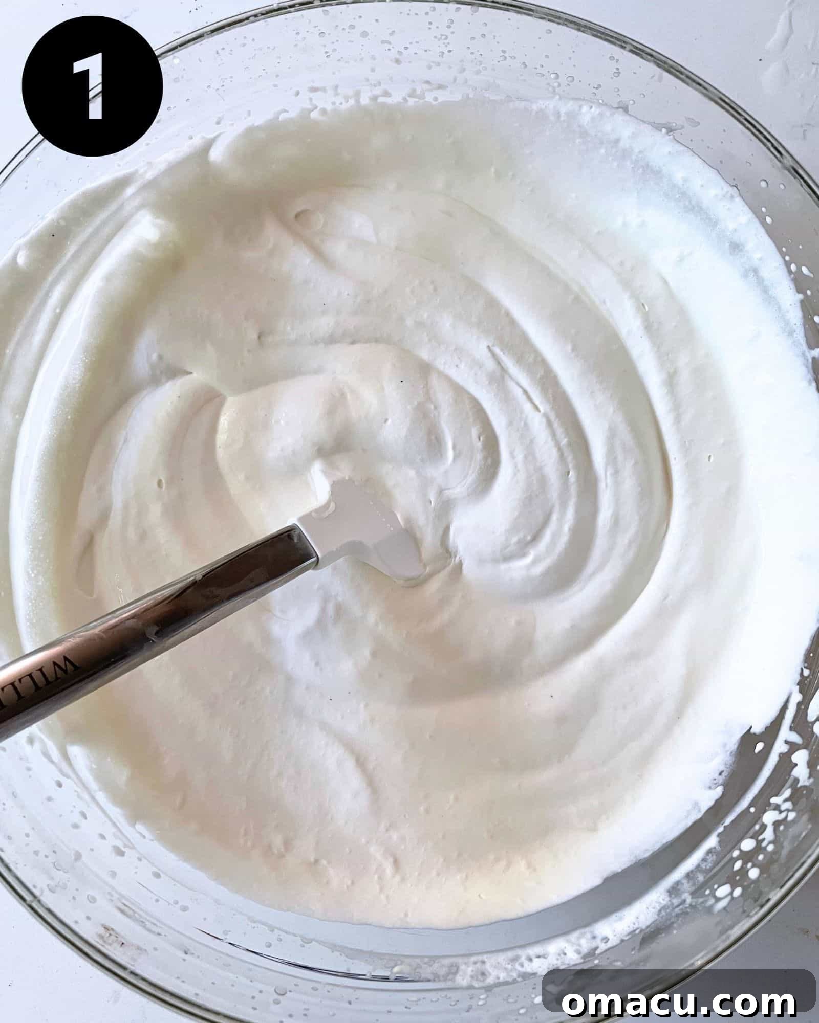 A mixing bowl filled with freshly whipped cream, ready to be blended with marshmallow fluff, vanilla extract, and sweetened condensed milk for the ice cream base.