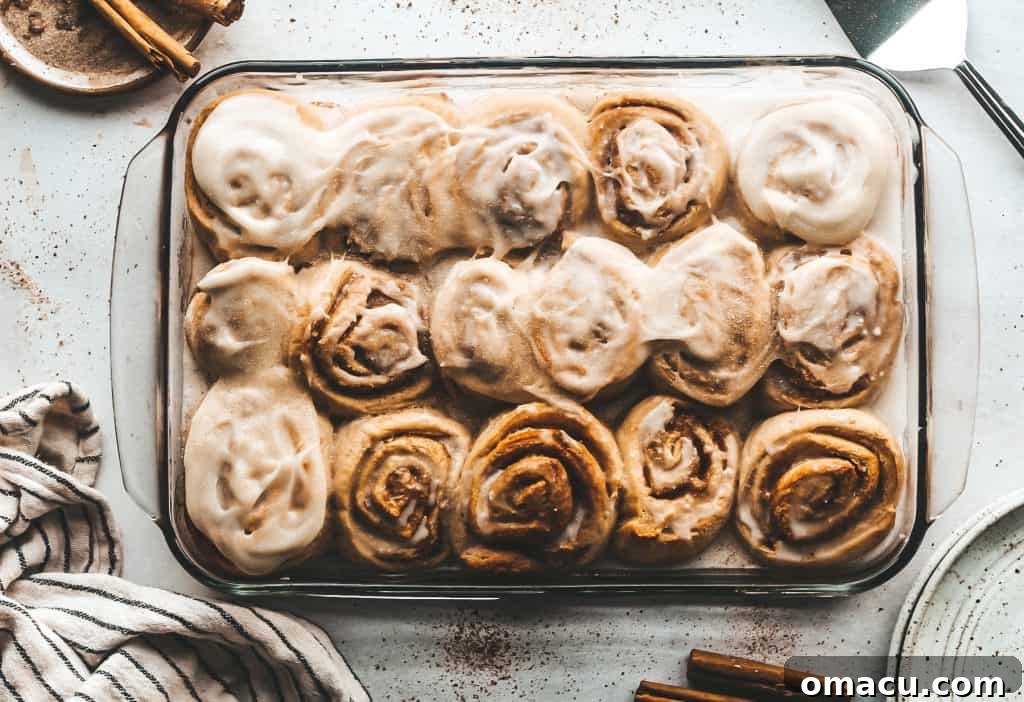 Delicious pear cinnamon rolls topped with cream cheese frosting, ready to be enjoyed.