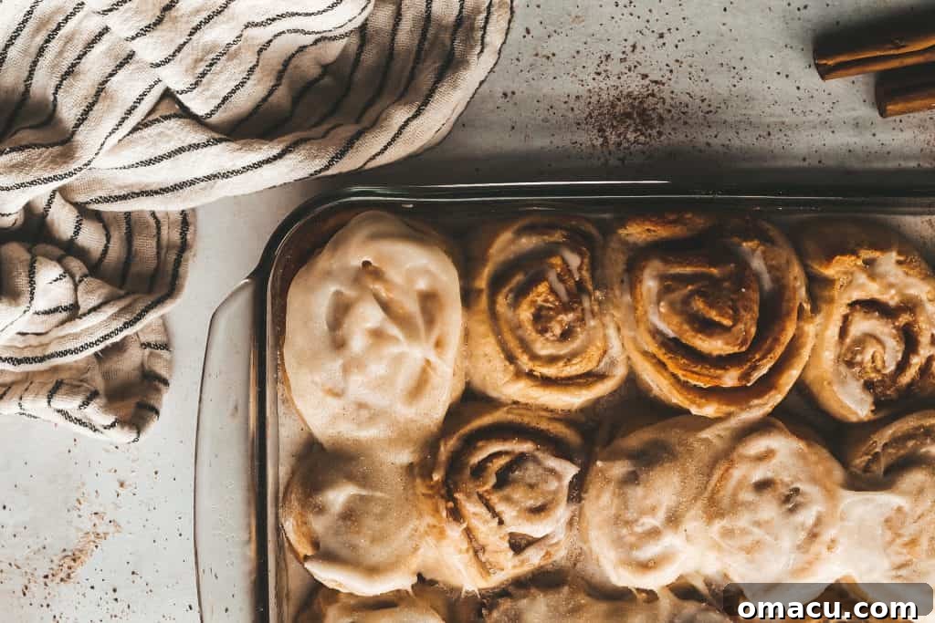 Close-up shot of a single pear cinnamon roll, showcasing its soft texture and generous frosting.