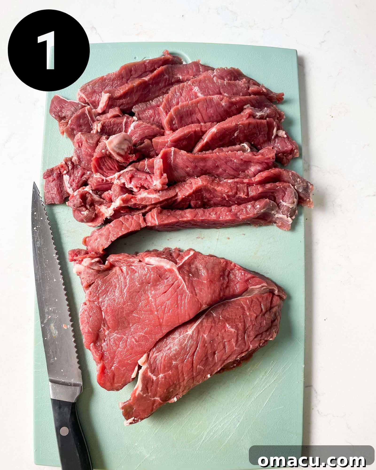 Thinly sliced sirloin steak laid out on a cutting board, ready for seasoning and coating.