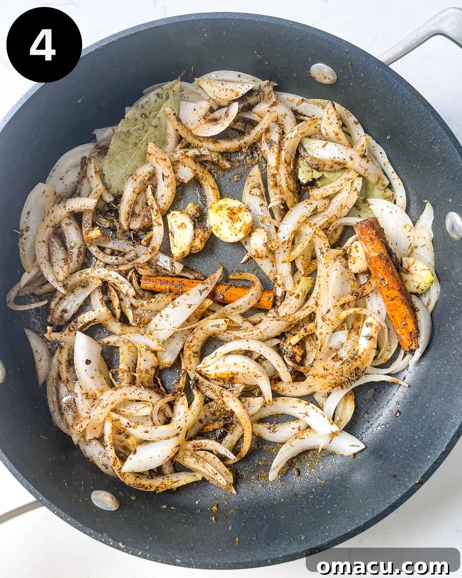sauteed onions, spices, and bay leaves in a pan, releasing their aromas.